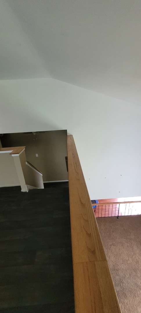 stairway with vaulted ceiling and carpet floors