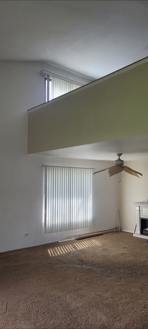carpeted empty room featuring ceiling fan and a wealth of natural light
