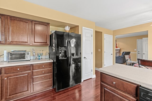 kitchen with black fridge with ice dispenser, dark wood-style flooring, and light countertops