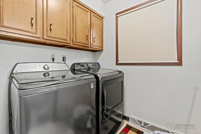 washroom featuring washing machine and clothes dryer and cabinet space