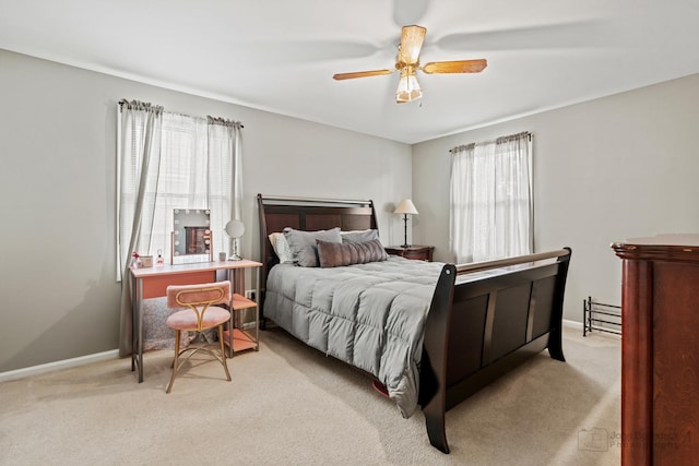 bedroom featuring light colored carpet, baseboards, and ceiling fan