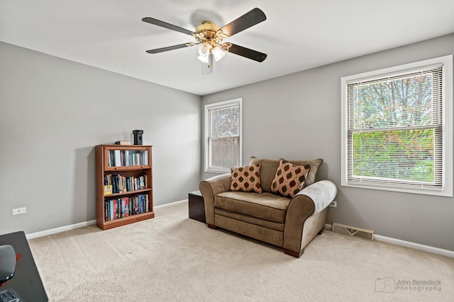 living area with carpet flooring, a ceiling fan, and baseboards