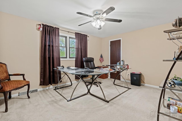 home office featuring light carpet, a ceiling fan, and baseboards