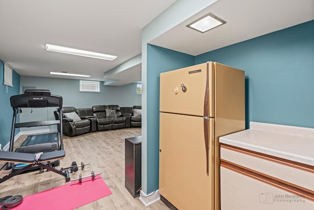 kitchen featuring freestanding refrigerator, light wood-type flooring, and light countertops