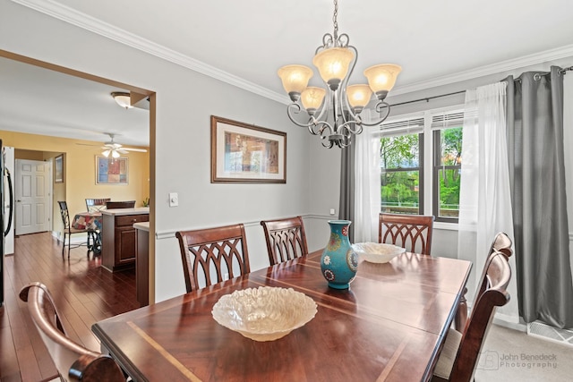 dining space featuring a chandelier, crown molding, hardwood / wood-style floors, and baseboards