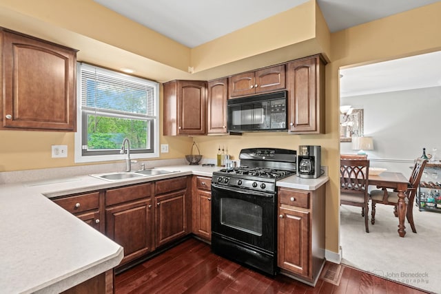 kitchen featuring black appliances, a sink, light countertops, dark wood finished floors, and brown cabinets
