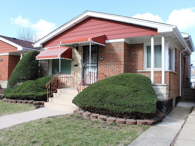 bungalow featuring brick siding