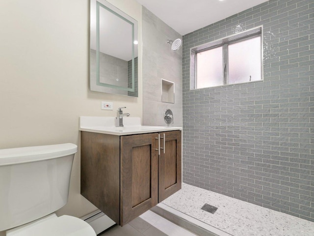 bathroom featuring vanity, toilet, tile patterned flooring, and tiled shower