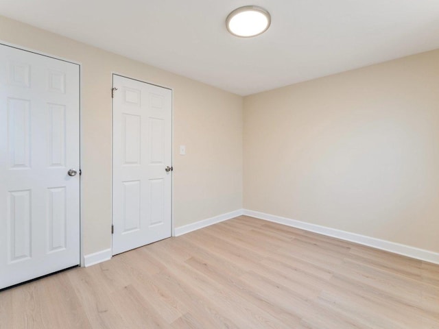 unfurnished bedroom with light wood-style floors and baseboards