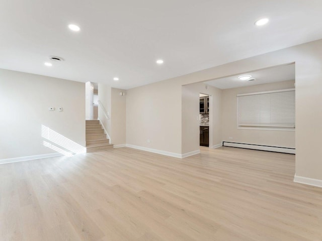 unfurnished living room with stairway, light wood finished floors, baseboards, and baseboard heating