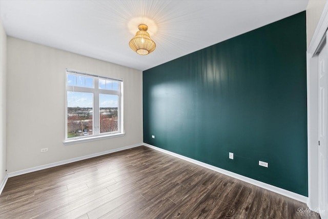 spare room featuring wood finished floors and baseboards
