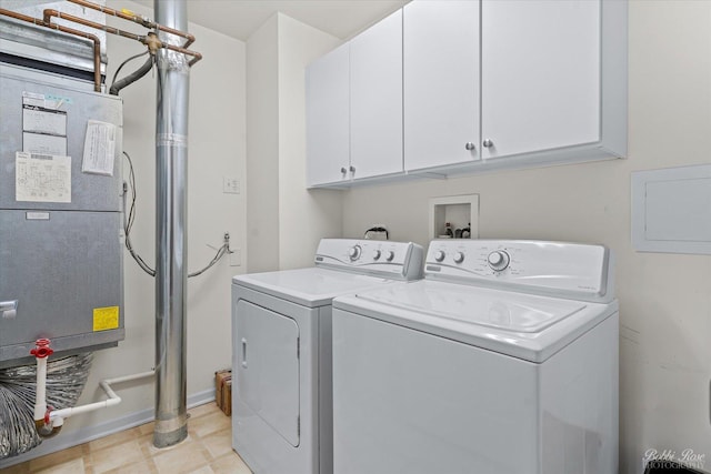 washroom featuring heating unit, cabinet space, electric panel, washer and clothes dryer, and baseboards