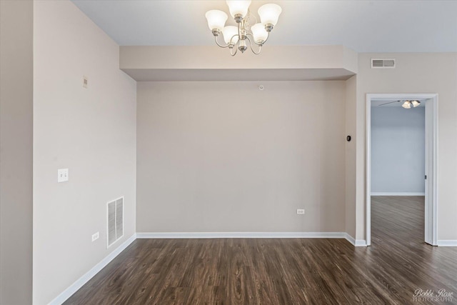 unfurnished dining area with a notable chandelier, baseboards, visible vents, and dark wood finished floors