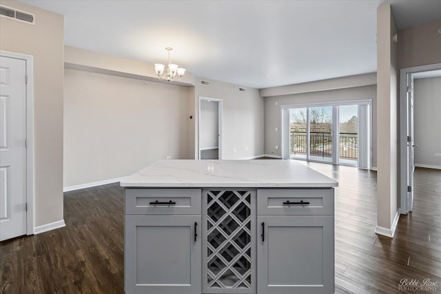 kitchen with gray cabinetry, open floor plan, visible vents, and dark wood-style floors