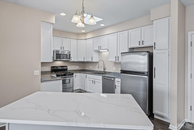 kitchen featuring a sink, light stone counters, white cabinetry, dark wood-style floors, and appliances with stainless steel finishes