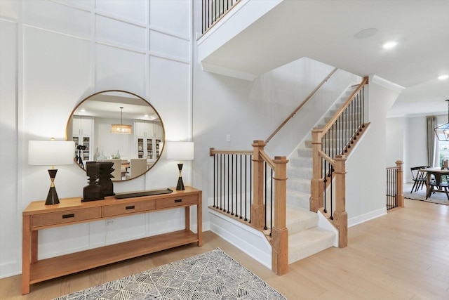 stairs with recessed lighting, baseboards, and wood finished floors