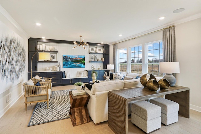 living area with an inviting chandelier, visible vents, baseboards, light wood-style floors, and ornamental molding