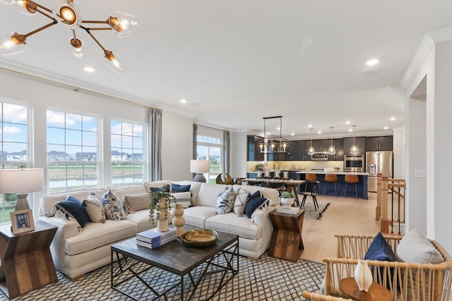 living area featuring an inviting chandelier, ornamental molding, and recessed lighting