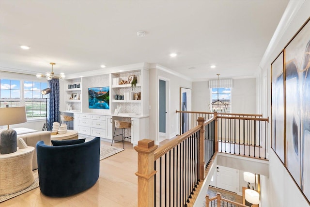living area with crown molding, light wood-style flooring, a notable chandelier, and recessed lighting