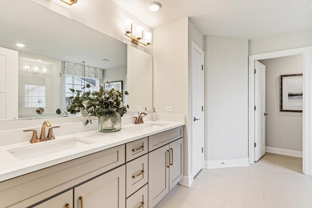 full bath with a sink, double vanity, tiled shower, and tile patterned flooring