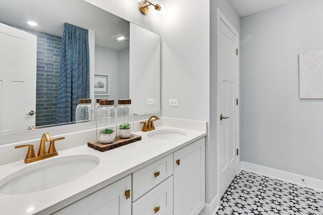 full bathroom featuring baseboards, tile patterned floors, double vanity, and a sink