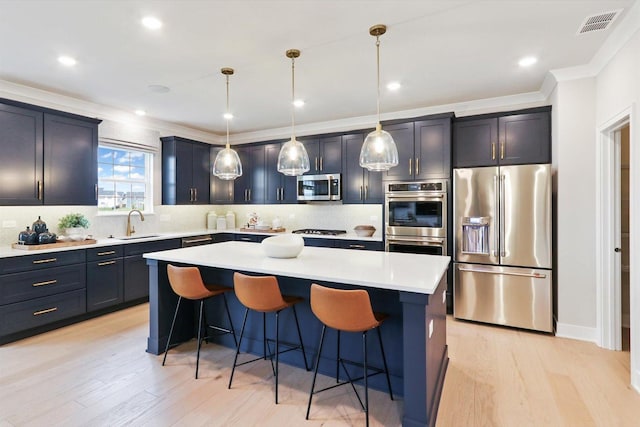 kitchen with light wood-type flooring, a breakfast bar area, and stainless steel appliances