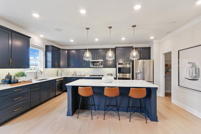 kitchen with appliances with stainless steel finishes, a center island, a breakfast bar area, and a sink