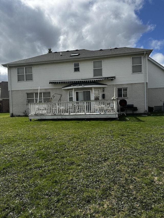 back of property featuring a yard and a wooden deck