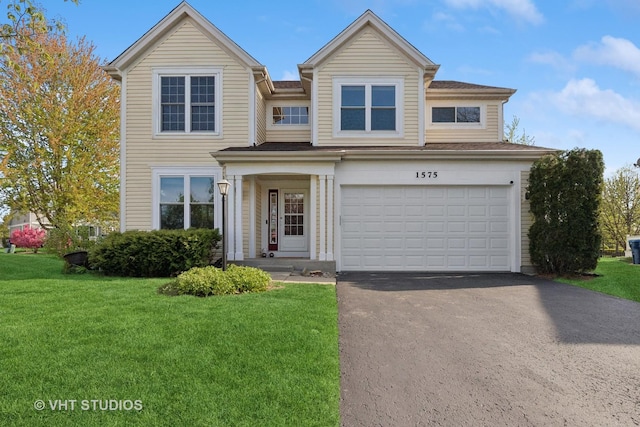 view of front of home with asphalt driveway, a front lawn, and a garage