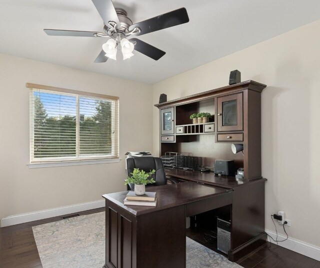 office space featuring baseboards, ceiling fan, and dark wood-style floors