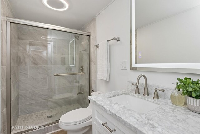 bathroom with a shower stall, vanity, and toilet