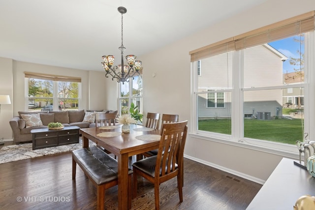 dining area with a chandelier, dark wood-style floors, and baseboards