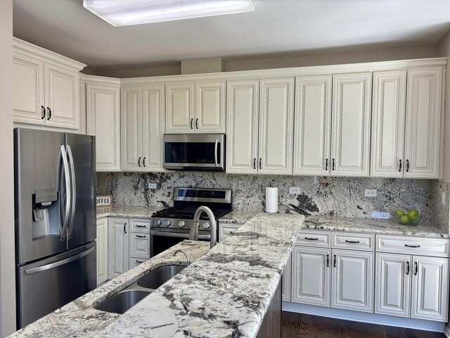 kitchen featuring appliances with stainless steel finishes, light stone countertops, decorative backsplash, and white cabinetry
