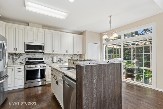 kitchen featuring stainless steel appliances, a sink, white cabinets, and backsplash