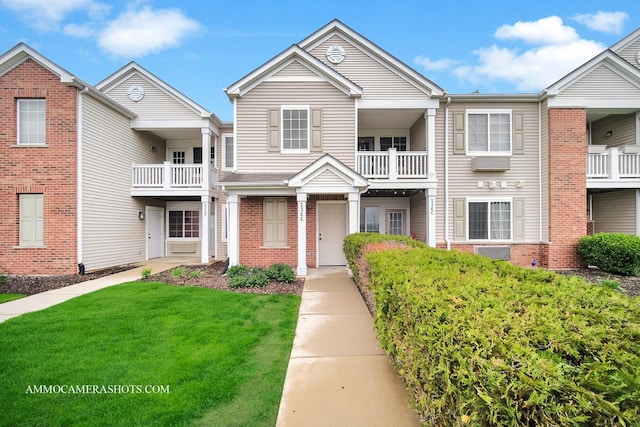 view of property with a front lawn and brick siding