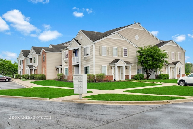 view of front of property featuring a front lawn, brick siding, and a residential view