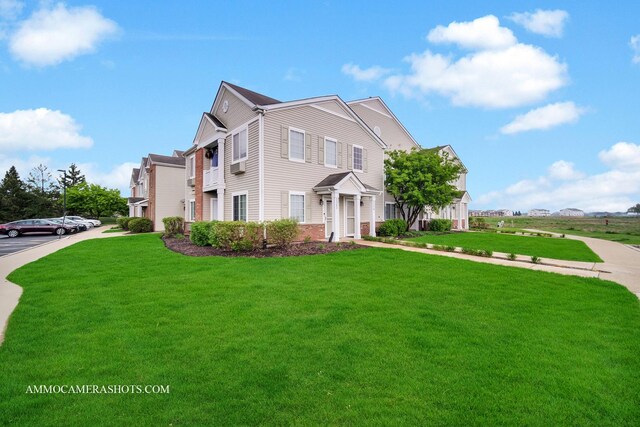view of front of property featuring brick siding and a front lawn
