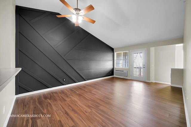 unfurnished living room featuring a ceiling fan, baseboards, a wall mounted AC, and wood finished floors