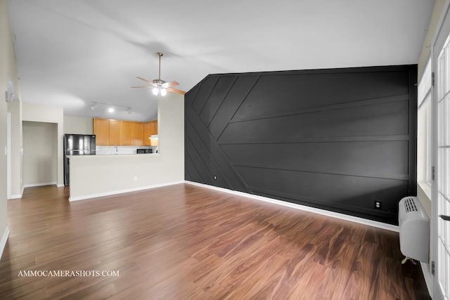 unfurnished living room with baseboards, wood finished floors, ceiling fan, and track lighting