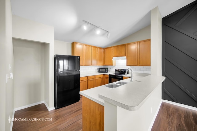 kitchen with a sink, tasteful backsplash, black appliances, light countertops, and dark wood-style floors