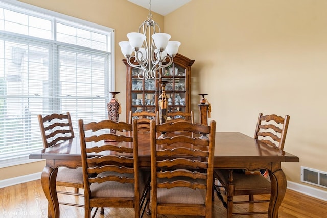 12116 Winterberry Ln, Plainfield, IL 60585 - dining room with a chandelier, wood finished floors, and baseboards