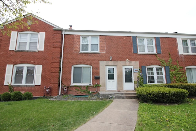 view of front of home featuring a front lawn and brick siding