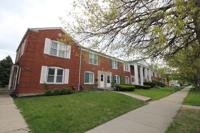 view of front of property with a front lawn and brick siding