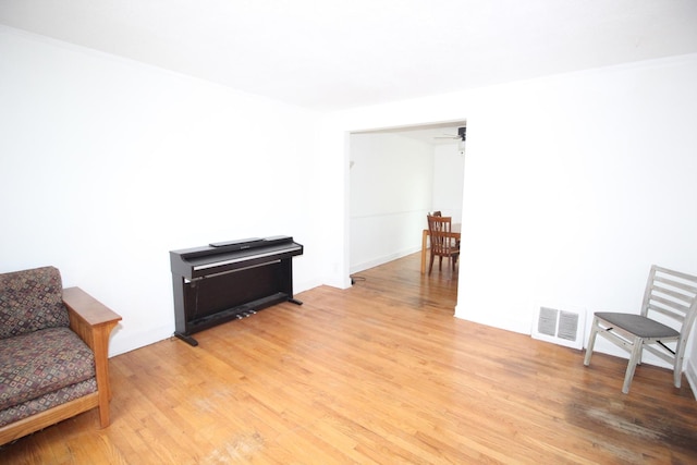 living area featuring light wood finished floors and ceiling fan