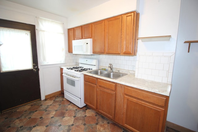 kitchen with white appliances, a sink, light countertops, decorative backsplash, and brown cabinets