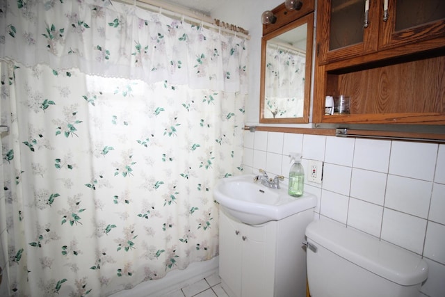 full bath with toilet, vanity, tasteful backsplash, tile patterned floors, and shower / bath combination with curtain