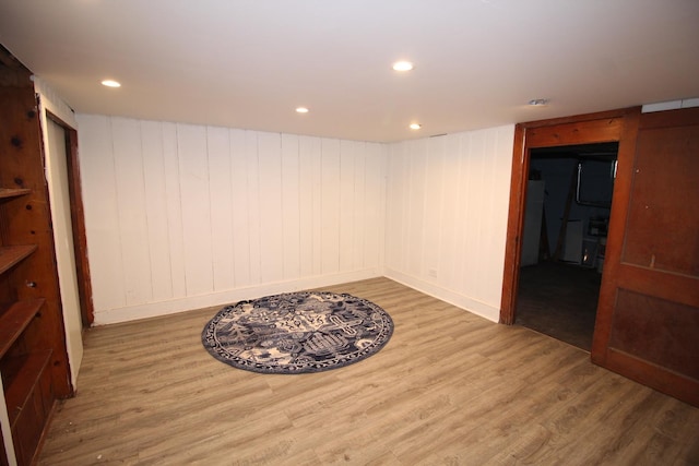 finished below grade area featuring wood finished floors, recessed lighting, and baseboards