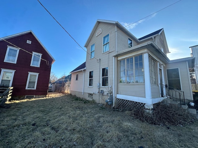 rear view of property featuring a sunroom