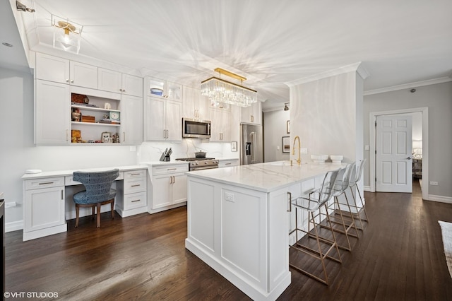 1122 N Dearborn St Unit 10A, Chicago, IL 60610 - kitchen featuring a peninsula, a breakfast bar area, high quality appliances, white cabinets, and crown molding