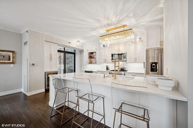 1122 N Dearborn St Unit 10A, Chicago, IL 60610 - kitchen featuring a peninsula, dark wood-style flooring, light stone counters, and appliances with stainless steel finishes
